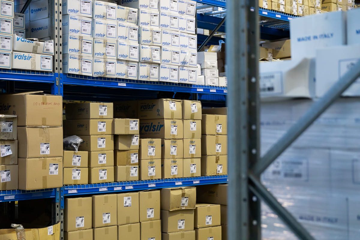 Stacked boxes with stock on shelves in a warehouse