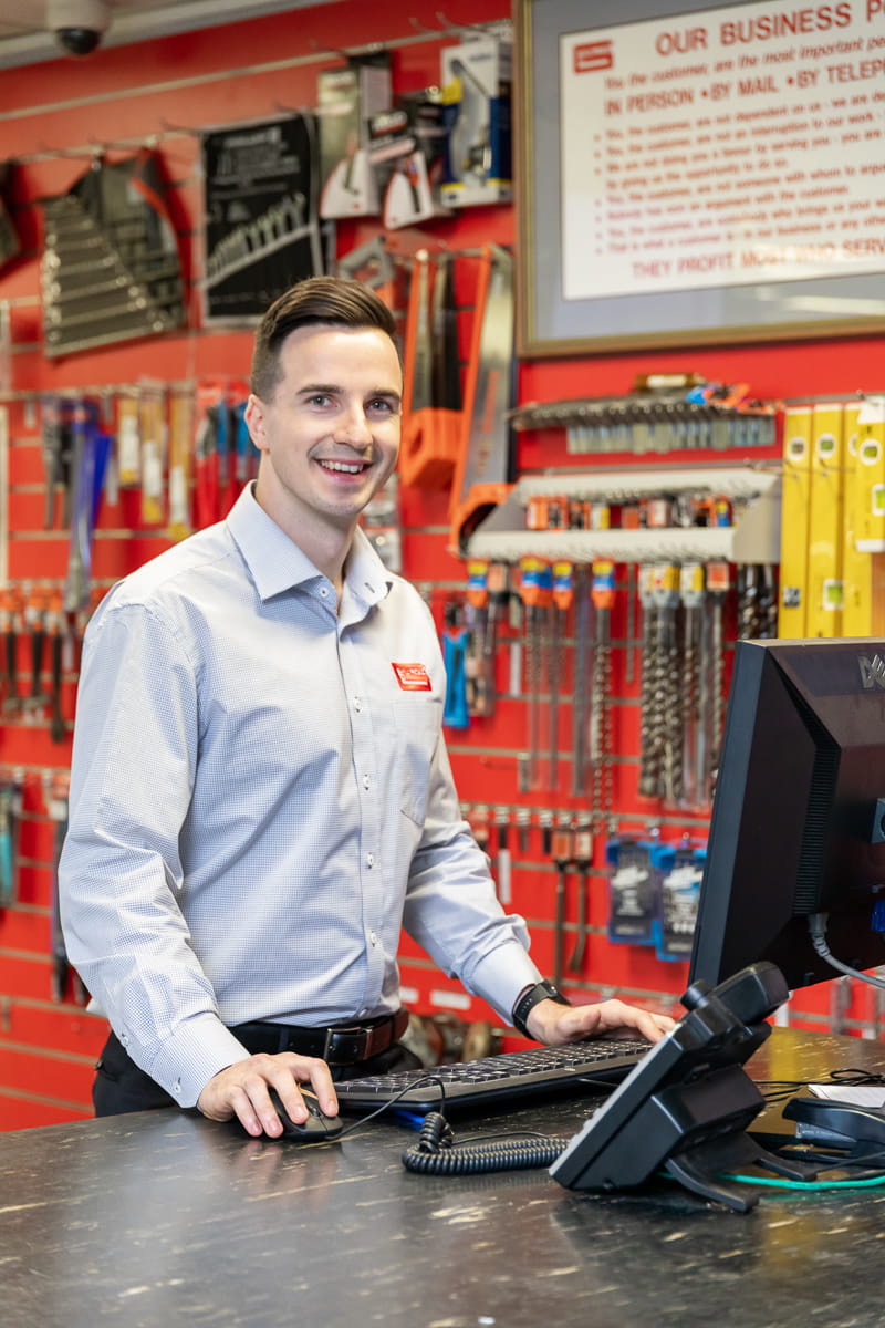 Close up of Galvins employee standing at sales counter and smiling