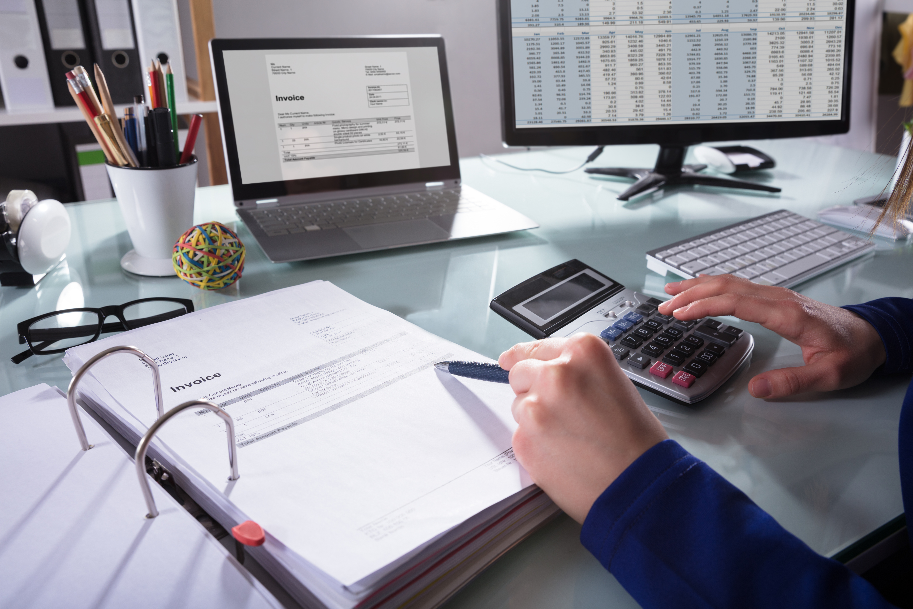 Businessperson calculating invoices at desk