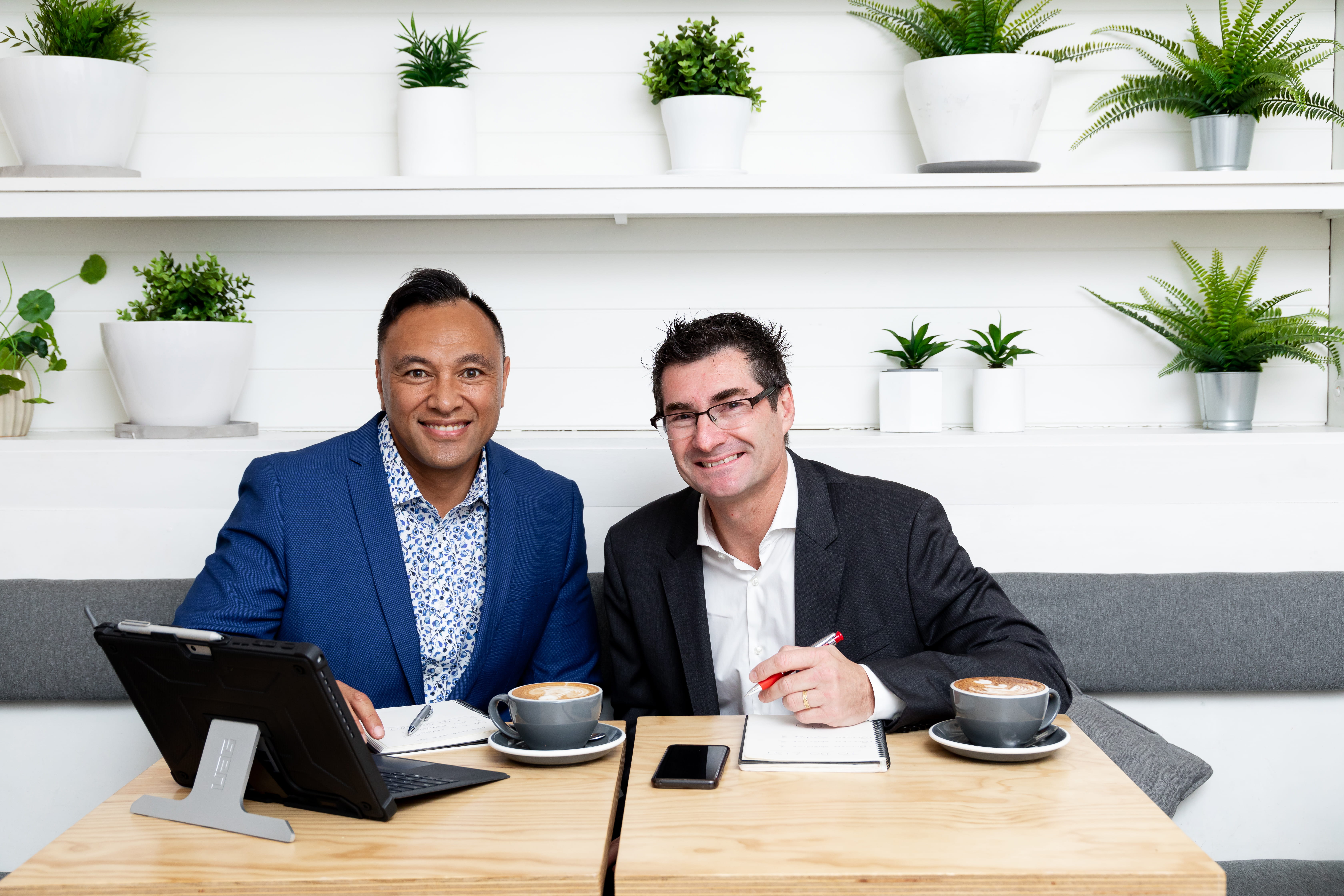 Precise employees Vincent and Mark collaborating in a coffee shop about an Epicor ERP customer