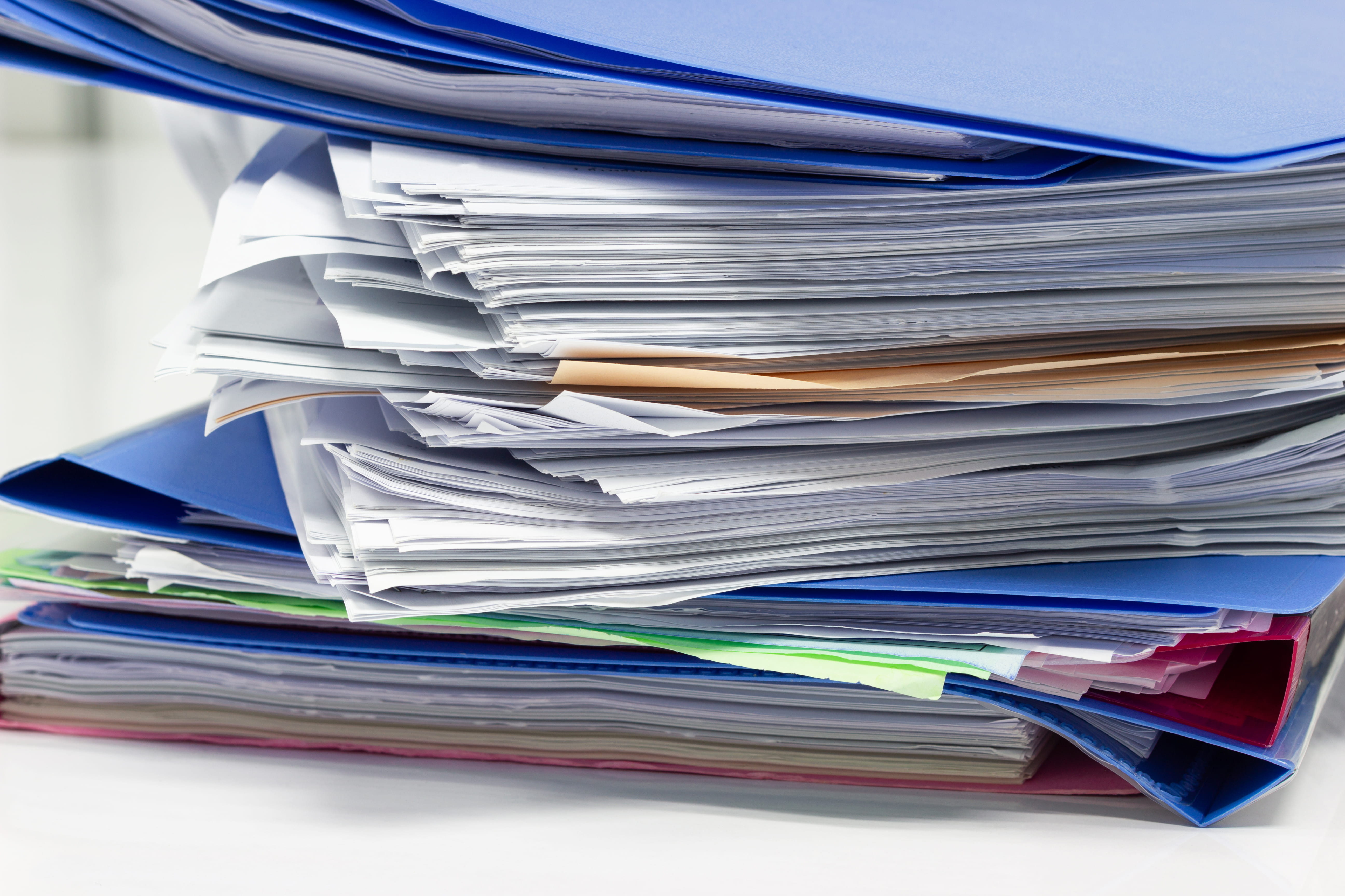 Stacks of files with paper invoices like this are a thing of the past with an automated procurement solution