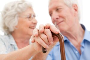 Older couple holding hands in aged care facility